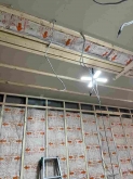 空気層に断熱材を詰めています。
石膏ボードを張り重ねて天井と壁をつくっていきます。